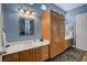 Well-lit bathroom with double sink vanity, storage cabinets, and decorative mirror at 6230 Calm Brook Ct, Las Vegas, NV 89149
