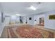 Large bonus room featuring neutral carpet, stairs, and open access to the kitchen area at 6230 Calm Brook Ct, Las Vegas, NV 89149