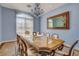 Elegant dining room features a large glass-top table, chandelier, and large window for plenty of sunlight at 6230 Calm Brook Ct, Las Vegas, NV 89149