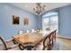 Bright dining room with a large glass-top table, chandelier, and large window overlooking neighborhood at 6230 Calm Brook Ct, Las Vegas, NV 89149