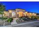 Charming single-story home with a stucco facade, stone accents, and landscaped front yard at dusk at 6230 Calm Brook Ct, Las Vegas, NV 89149