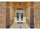 Elegant double front doors with decorative glass, framed by stone pillars with security system at 6230 Calm Brook Ct, Las Vegas, NV 89149
