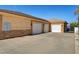 Attached three-car garage with white doors and spacious driveway and secure gate at 6230 Calm Brook Ct, Las Vegas, NV 89149