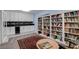 Home library with built-in bookshelves, a beverage cooler, and a comfortable reading area at 6230 Calm Brook Ct, Las Vegas, NV 89149