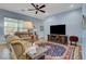 Comfortable living room with plush seating, ceiling fan, and large windows at 6230 Calm Brook Ct, Las Vegas, NV 89149