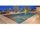 An elevated view of the backyard pool and spa combo showcases palm trees and lounge furniture at 6230 Calm Brook Ct, Las Vegas, NV 89149