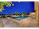 Backyard featuring a pool and spa, surrounded by lush landscaping and enhanced by evening lighting at 6230 Calm Brook Ct, Las Vegas, NV 89149