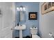 Charming powder room with pedestal sink, globe sconces, and decorative wall art at 6230 Calm Brook Ct, Las Vegas, NV 89149