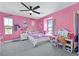 Bright pink bedroom with a ceiling fan, window nook, and unique decor at 625 Honesty Ct, Henderson, NV 89011
