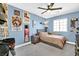 Cozy bedroom with light blue walls, sports-themed decor, and a comfortable bed under a ceiling fan at 625 Honesty Ct, Henderson, NV 89011