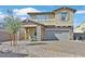 Charming two-story home featuring stone accents, a well-manicured yard, and a welcoming covered front porch at 625 Honesty Ct, Henderson, NV 89011