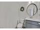 Clean half-bath featuring a round mirror, updated vanity, and modern fixtures at 625 Honesty Ct, Henderson, NV 89011