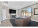 Cozy living room with a plush couch, large TV, and access to the outdoor patio at 625 Honesty Ct, Henderson, NV 89011