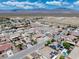 Expansive aerial view of a desert neighborhood with single-story homes and mountainous background under sunny skies at 654 Mazelle Ln, Pahrump, NV 89060