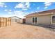 A view of the backyard featuring dirt, landscaping, and a wood wall on the back of the house at 654 Mazelle Ln, Pahrump, NV 89060