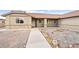 Front of single story home with tan exterior, red tile roof and desert landscaping in front at 654 Mazelle Ln, Pahrump, NV 89060