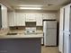 Bright kitchen featuring white cabinets and appliances, maximizing storage and functionality at 6865 Tamarus St # 202, Las Vegas, NV 89119
