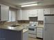 Functional kitchen with white cabinetry and appliances, offering a clean and efficient cooking space at 6865 Tamarus St # 202, Las Vegas, NV 89119