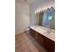 Bathroom with a double sink vanity, a large mirror, and abundant lighting at 7255 W La Madre Way, Las Vegas, NV 89149