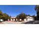 A single-story home with a three-car garage, desert landscaping, and mature trees at 7255 W La Madre Way, Las Vegas, NV 89149