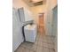 An efficient laundry room with tile floors, washer, dryer and storage cabinets at 7255 W La Madre Way, Las Vegas, NV 89149