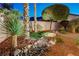Landscaped backyard featuring rocks, trees, grass, and a charming stone pathway over a dry creek bed at 733 Secret London Ave, Las Vegas, NV 89178