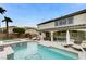 Backyard featuring a pool, spa, covered patio with seating and retaining wall with landscaping at 733 Secret London Ave, Las Vegas, NV 89178