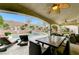 Backyard view of the pool, spa, covered patio with seating, and retaining wall with landscaping at 733 Secret London Ave, Las Vegas, NV 89178