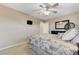 Bright bedroom featuring carpet, ceiling fan, large windows, mounted TV, and wall mirror at 733 Secret London Ave, Las Vegas, NV 89178
