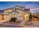 Inviting two-story home with arched entry, landscaping, and a charming facade at dusk at 733 Secret London Ave, Las Vegas, NV 89178