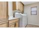 Laundry room features a washer, dryer, cabinet space, a sink and a window at 733 Secret London Ave, Las Vegas, NV 89178
