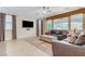 Comfortable living room featuring plush seating, large windows, and tile flooring at 733 Secret London Ave, Las Vegas, NV 89178