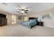 Expansive main bedroom featuring neutral walls, carpeted floor, a ceiling fan, and a glimpse into the ensuite bathroom at 733 Secret London Ave, Las Vegas, NV 89178