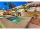 Luxurious backyard oasis featuring a hot tub, desert plants, and retaining wall for added privacy at 733 Secret London Ave, Las Vegas, NV 89178