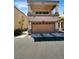 Two-story home with a two-car garage, balcony, and neutral stucco exterior exudes curb appeal at 7873 Running Doe Ct, Las Vegas, NV 89149