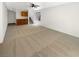 Bright, carpeted living room with a ceiling fan, built-in bar, and staircase access at 7873 Running Doe Ct, Las Vegas, NV 89149