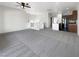 Bright living room featuring neutral walls, plush carpet, modern ceiling fan, and easy access to the kitchen at 7873 Running Doe Ct, Las Vegas, NV 89149