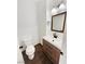 Stylish powder room featuring wood-look floors, updated vanity, modern mirror, and a contemporary toilet at 7873 Running Doe Ct, Las Vegas, NV 89149