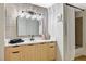 Bright bathroom featuring a wood vanity with black hardware and a shower with a neutral-toned tile surround at 8000 Badura Ave # 1007, Las Vegas, NV 89113