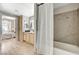 Bathroom featuring a wood vanity and shower with neutral toned tile surround, near bedroom with natural light at 8000 Badura Ave # 1007, Las Vegas, NV 89113