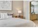 Bedroom featuring a nightstand and view of the bathroom with wood vanity and black hardware at 8000 Badura Ave # 1007, Las Vegas, NV 89113