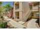 Exterior view of an apartment building with stairs leading to upper-level units and well-maintained landscaping at 8000 Badura Ave # 1007, Las Vegas, NV 89113
