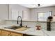 Close-up of kitchen sink, featuring white marble countertops and modern faucet fixture at 8000 Badura Ave # 1007, Las Vegas, NV 89113