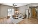 Open-concept living room with a neutral color palette, wood flooring, and a sliding door to the balcony at 8000 Badura Ave # 1007, Las Vegas, NV 89113