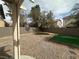 Gravel backyard features artificial turf patches and a large tree for shade at 8215 Shell Beach Ct, Las Vegas, NV 89117