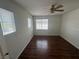 Bedroom features hardwood flooring, ceiling fan and multiple windows for natural light at 8215 Shell Beach Ct, Las Vegas, NV 89117