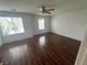 This bedroom features hardwood flooring, two windows and a ceiling fan at 8215 Shell Beach Ct, Las Vegas, NV 89117