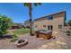 Private backyard features a hot tub, built in fire pit, lush landscaping, and play structure at 8333 Valley Stream Ave, Las Vegas, NV 89131