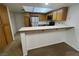 Bright kitchen featuring wood cabinetry, stainless steel appliances, and a convenient breakfast bar at 8940 Antioch Way, Las Vegas, NV 89117
