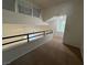 Hallway landing featuring a railing overlooking the living area with large windows at 8940 Antioch Way, Las Vegas, NV 89117